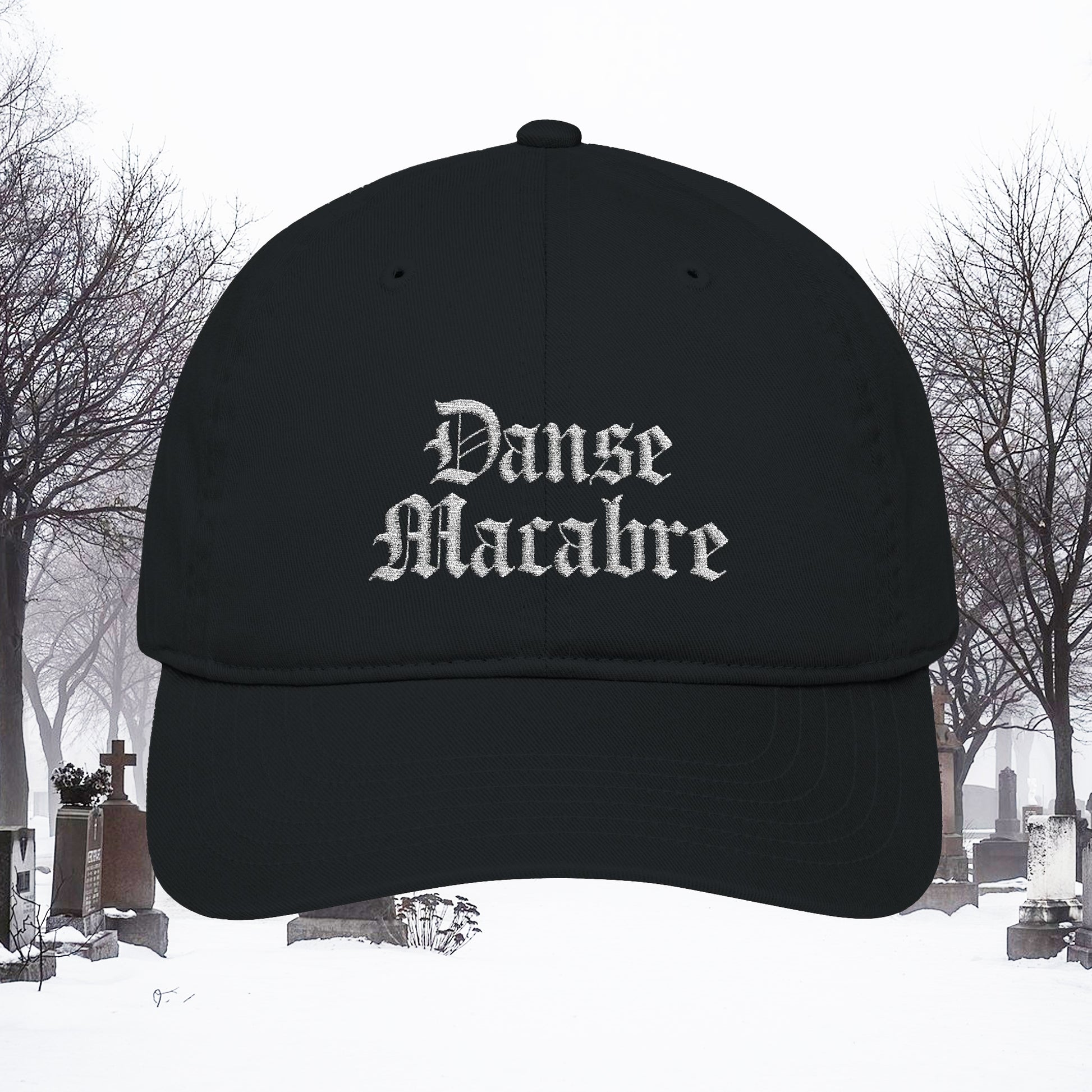 Grant Us Night black cap with white embroidered 'Danse Macabre' text in a snowy cemetery