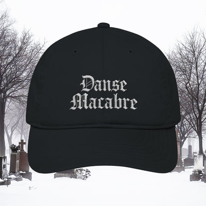 Grant Us Night black cap with white embroidered 'Danse Macabre' text in a snowy cemetery