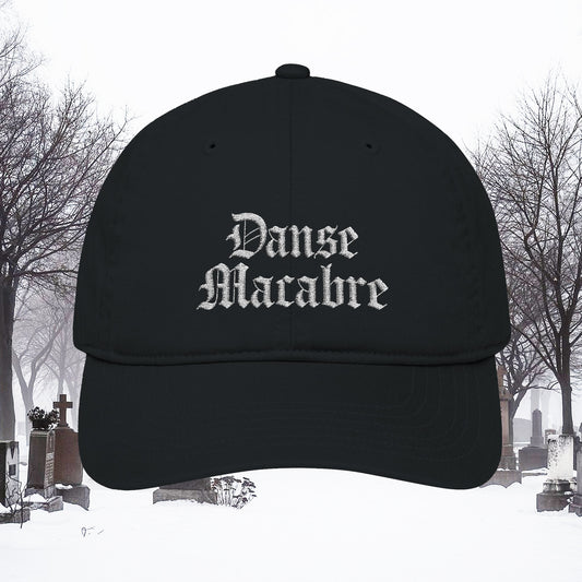 Grant Us Night black cap with white embroidered 'Danse Macabre' text in a snowy cemetery