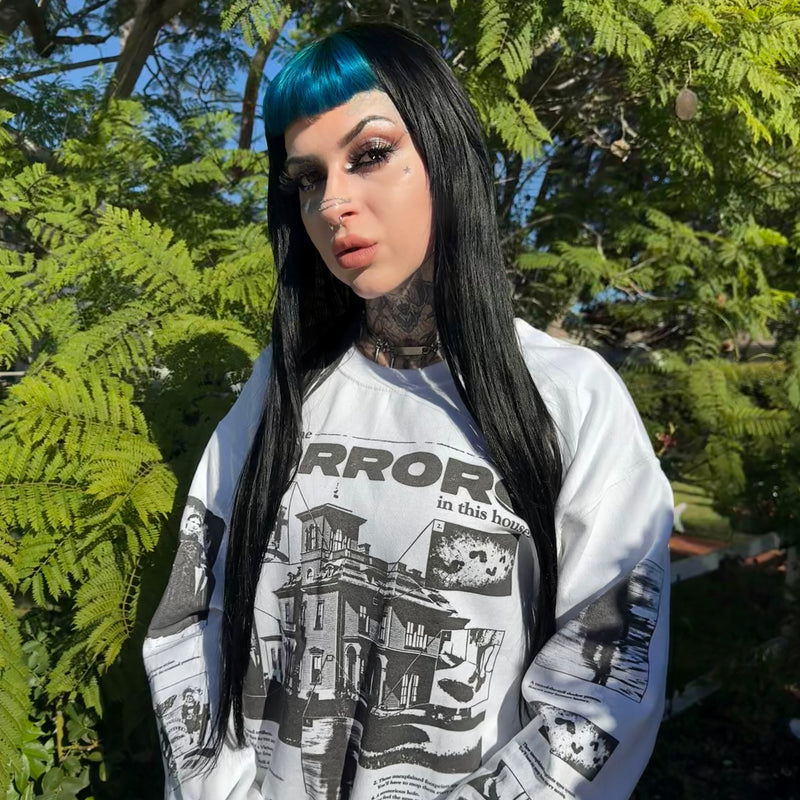 Person wearing a Grant Us Night graphic sweatshirt with text and images in an outdoor setting