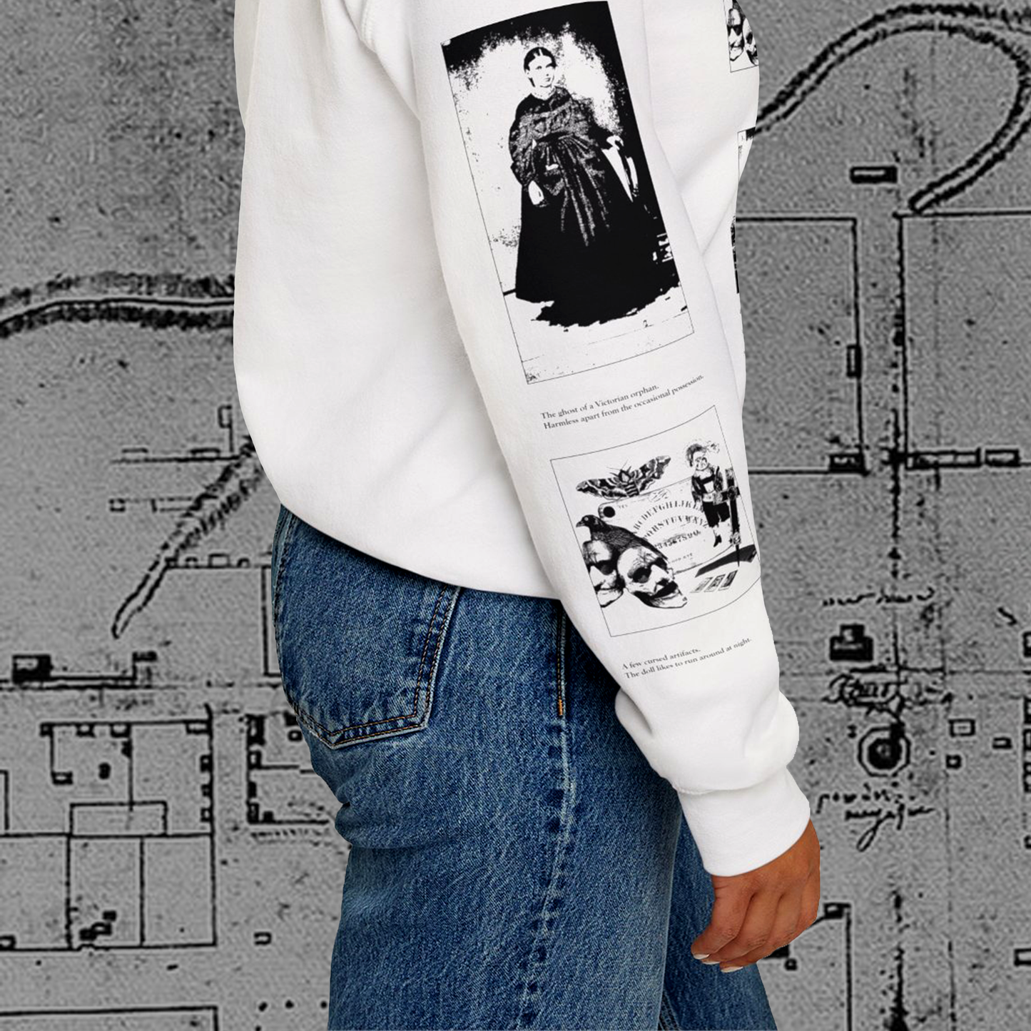 Grant Us Night Horror House white sweatshirt sleeve with black graphic design text and a haunted house with ghosts and footprints and cursed objects and illustrations on a textured background