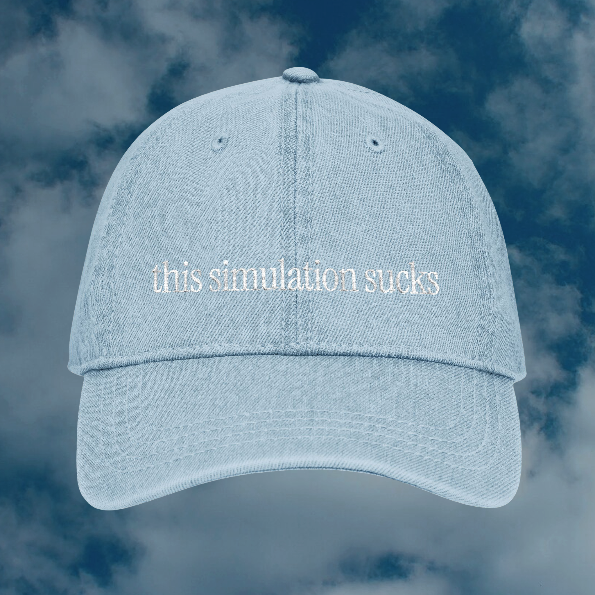 Grant Us Night Simulation light blue denim cap with 'this simulation sucks' white text embroidered against a blue sky background