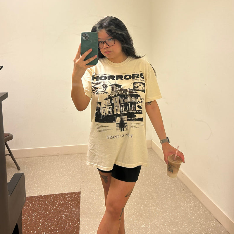 Person wearing a graphic t-shirt taking a mirror selfie.